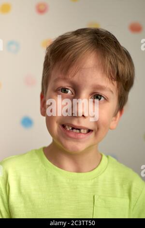 Kind zeigt fehlende Zähne, er hat zwei Kalbszähne verloren. Nahaufnahme Porträt des blonden kaukasischen Jungen lächeln ohne zwei Vorderzähne. Stockfoto