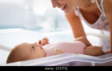 Portrait der schönen liebevollen Mutter spielen erste Spiele mit ihrem Baby Stockfoto