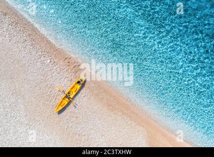 Luftaufnahme des Sandstrandes mit gelbem Kanu und blauem Meer Stockfoto