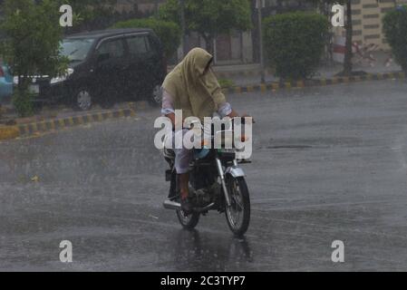 Lahore, Pakistan. Juni 2020. Pakistanische Pendler, die während eines starken Regenguts vor dem Monsun der Sommersaison in der Provinzhauptstadt Lahore durch eine Straße fahren (Foto: Rana Sajid Hussain/Pacific Press) Quelle: Pacific Press Agency/Alamy Live News Stockfoto