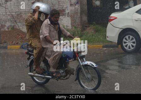 Lahore, Pakistan. Juni 2020. Pakistanische Pendler, die während eines starken Regenguts vor dem Monsun der Sommersaison in der Provinzhauptstadt Lahore durch eine Straße fahren (Foto: Rana Sajid Hussain/Pacific Press) Quelle: Pacific Press Agency/Alamy Live News Stockfoto