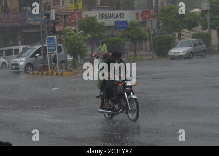 Lahore, Pakistan. Juni 2020. Pakistanische Pendler, die während eines starken Regenguts vor dem Monsun der Sommersaison in der Provinzhauptstadt Lahore durch eine Straße fahren (Foto: Rana Sajid Hussain/Pacific Press) Quelle: Pacific Press Agency/Alamy Live News Stockfoto