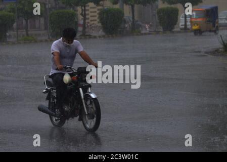 Lahore, Pakistan. Juni 2020. Pakistanische Pendler, die während eines starken Regenguts vor dem Monsun der Sommersaison in der Provinzhauptstadt Lahore durch eine Straße fahren (Foto: Rana Sajid Hussain/Pacific Press) Quelle: Pacific Press Agency/Alamy Live News Stockfoto