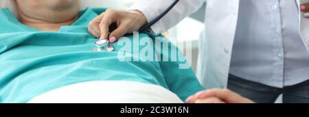 Kranker Mann liegt in der Klinik auf dem Bett, untersucht der Arzt Stockfoto