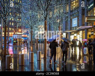 Manhattan, New York, Vereinigte Staaten von Amerika - Menschen vor dem Time Warner Center, einem Gebäudekomplex in Columbus Circle an einem regnerischen Tag. Stockfoto