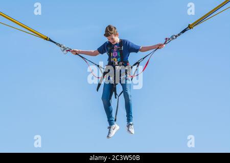 Junge auf einem Bungee-Seil-Trampolin-Fahrt. Stockfoto