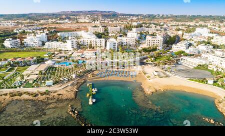 Vogelperspektive auf den Pernera-Strand in Protaras, Paralimni, Famagusta, Zypern. Die berühmte Touristenattraktion goldene Sandbucht mit Sonnenliegen, Wasser Stockfoto