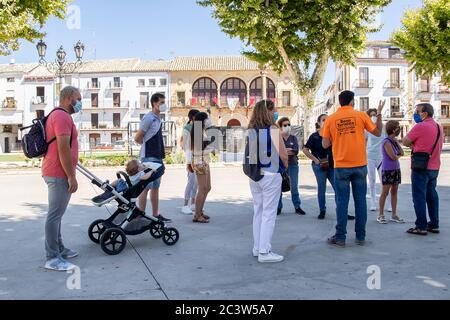 Baeza, Jaen, Spanien - 20. Juni 2020: Eine Gruppe von unbekannten Touristen mit einem professionellen Reiseführer Besuch der Altstadt von Baeza tragen schutzkleidung Stockfoto