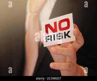 Keine Gefahr Wörter auf einer Karte in der Hand des Geschäftsmannes. Sichere Investition mit risikoarem Geschäftskonzept Stockfoto