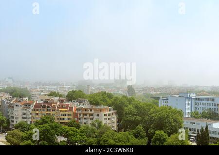 Dichter Nebel an einem sonnigen Sommertag in Varna. Dichter Nebel kam aus dem Meer und bedeckte die Stadt. Klima und Wetterveränderungen. Weitwinkelansicht. Stockfoto