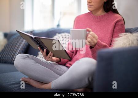 Nahaufnahme Der Frau Entspannen Auf Sofa Zu Hause Lesung Journal Stockfoto