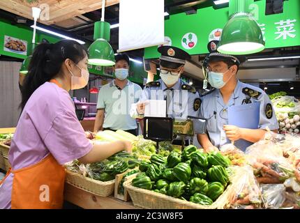 Peking, China. Juni 2020. Marktregulierungsmitarbeiter überprüfen den Lieferkanal von Gemüse auf einem Markt im Bezirk Haidian in Peking, Hauptstadt von China, 17. Juni 2020. Quelle: Ren Chao/Xinhua/Alamy Live News Stockfoto