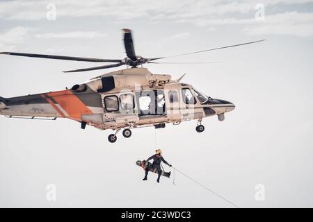 Suchen und retten SAR Hubschrauber Team hist eine verletzte Person Stockfoto