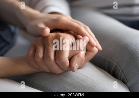 Millennial Tochter hält Hand der älteren Mutter Express Pflege Nahaufnahme Stockfoto