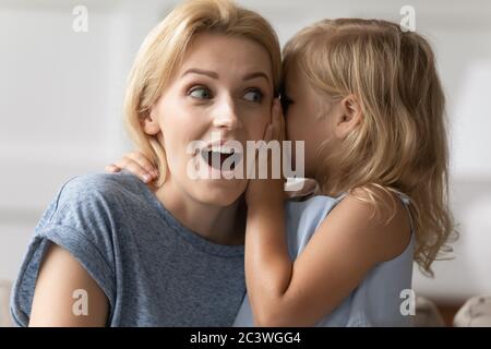 Verblüffte Mutter hört unglaubliche Nachrichten von kleinen Tochter Nahaufnahme Bild Stockfoto