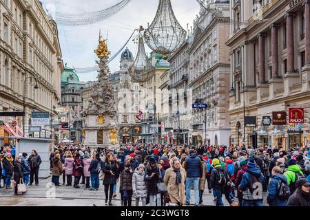 Die berühmte Grabenstraße mit vielen Touristen während der Weihnachtsferien, die Pestsäule in der Mitte der Straße, Wien, Österreich. Stockfoto