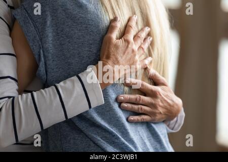 Nahaufnahme beschnitten Bild ältere Mutter umarmt Erwachsene Tochter Stockfoto