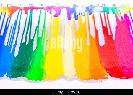 Bunte Siebdruckfarbe tropft auf weißem Hintergrund Stockfoto
