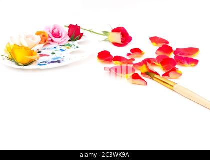 Aquarellpalette mit mehrfarbigen Rosenknospen und Kunstpinsel auf weißem Hintergrund. Die Farben des Sommers. Kreatives Konzept des bunten Sommers. Stockfoto