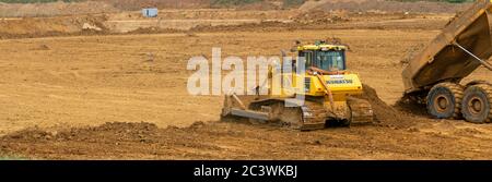 Kingsnorder Sand- und Kiesbruch, Durchführung von Explorationsarbeiten in Phase zwei. Ein Bulldozer glättet den oberen Boden, der übertransportiert wurde. Stockfoto