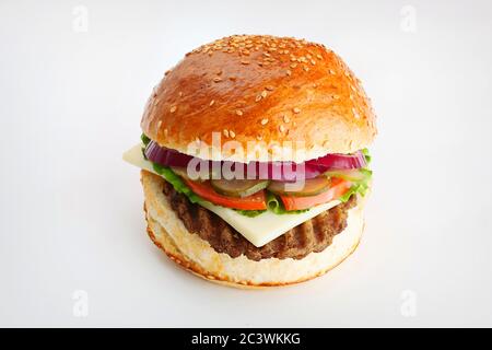 Saftiger Burger mit Zwiebelringen, Gurken, Salat, Käse auf weißem Hintergrund Stockfoto