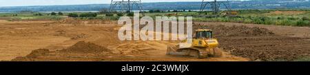 Kingsnorder Sand- und Kiesbruch, Durchführung von Explorationsarbeiten in Phase zwei. Ein Bulldozer glättet den oberen Boden, der übertransportiert wurde. Stockfoto