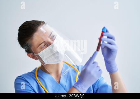 Arzt hält die Blutprobe über hellen Hintergrund Stockfoto
