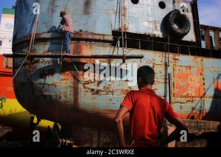 Hafenarbeiter führen Wartungsarbeiten am Rumpf eines Schiffes in Dhaka durch.Es gibt 28 Werften, die 30.96 Hektar des Buriganga Vorhores besetzen, wo Schiffe, Starts und Dampfer verschiedener Größen und Formen gebaut und repariert werden. Sie haben die letzten 50 Jahre ohne Genehmigung oder Richtlinien weiterbetrieben, wodurch der Fluss verschmutzt und in das Flussufer eingegriffen wird, was seine Schiffbarkeit verringert. Stockfoto