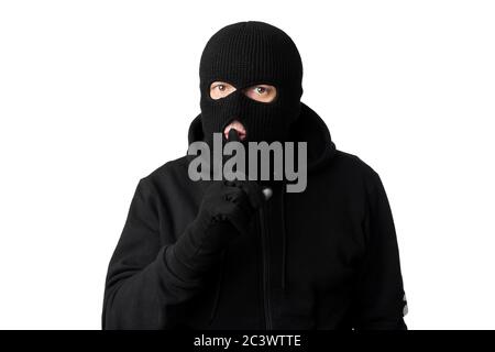 Dieb in schwarzer Balaclava hält Finger auf den Lippen Stockfoto