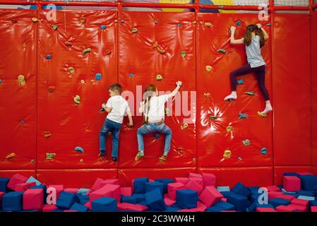 Kinder an der Kletterwand im Unterhaltungszentrum Stockfoto