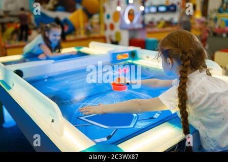 Mädchen spielen Air Hockey im Entertainment Center Stockfoto