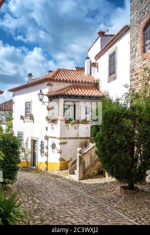 Blick auf gepflasterte enge Gassen im mittelalterlichen Obidos Portugal Stockfoto