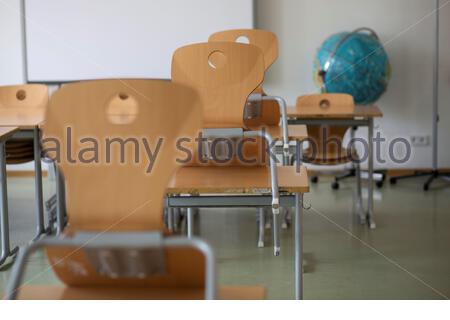 Schultische und -Stühle in einem leeren Klassenzimmer in Deutschland, da die Corona-Krise weiterhin hart auf die Bildung einwirkt. Stockfoto