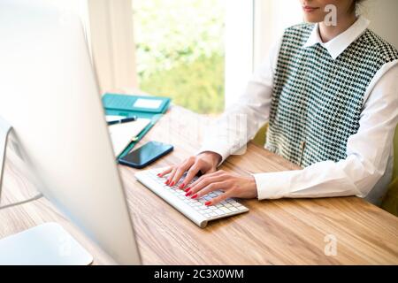 High-Angle-Aufnahme der Geschäftsfrau Hand tippen auf der Tastatur auf dem Schreibtisch. Stockfoto