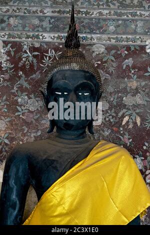 Wat Suthat Tempel, Gebäude und Meditation Bhudda Statuen Kopf und Schultern Porträt von schwarz gemaltem Buddha mit gelbem Tuch über der linken Schulter Stockfoto