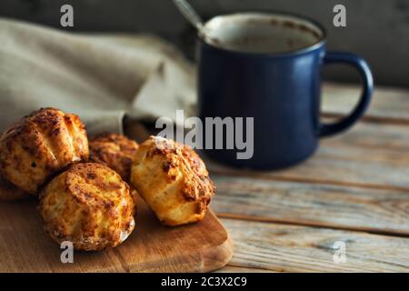 Hausgemachter Kuchen und Tasse Kaffee auf weißem Holzboden. Cupcakes mit Quark. Köstliches Dessert. Frühstückskonzept Stockfoto