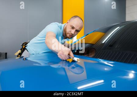 Autoverpackung mit Rakel installiert Schutzfolie Stockfoto
