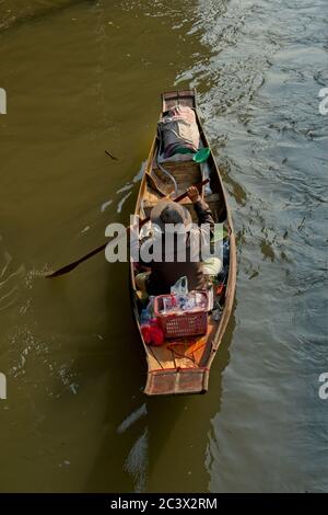 Einheimische auf Bangkoks schwimmenden Markt Einzelboot mit Frau paddeln Im hinteren Boot mit Lebensmitteln Porträt-Format in Bild bewegen Von unten Stockfoto