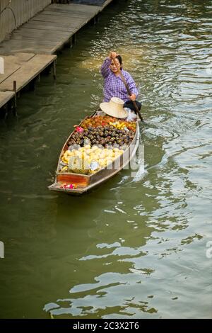 Einheimische auf Bangkoks schwimmenden Markt Einzelboot mit Frau paddeln Im hinteren Boot mit Lebensmitteln Porträt-Format in Bild bewegen Von oben Stockfoto