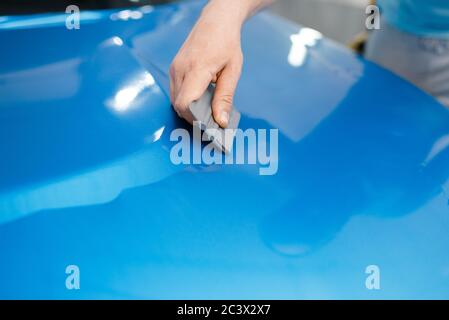 Autoverpackung, Mechaniker mit Rakel installiert Film Stockfoto