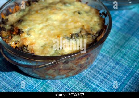 Kartoffelauflauf mit Käse im Glastopf auf blauer Serviette. Lebensstile, hausgemacht Stockfoto