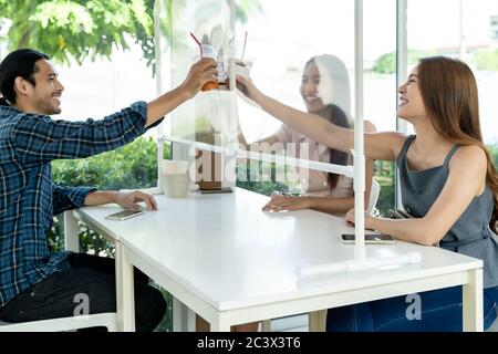 Asiatische Kunden jubeln und feiern soziale Distanzierung im Restaurant. Neue normale Lebensweise in Essen und Trinken Konzept. Stockfoto