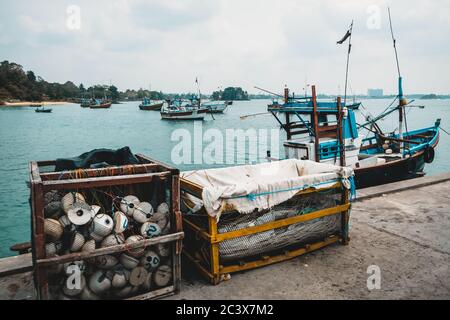 Fischtrawler und verschiedene Ausrüstung an einem Pier. Trawling als traditionelle lokale Handwerkskunst in Sri Lanka. Angelzubehör: Netz, Stroh, Seil. Stockfoto