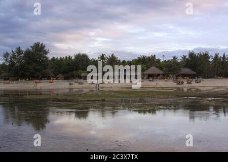 Wolkiger Tag am Strand mit wenigen Touristen bei Ebbe, auf Gili Air Insel, Lombok, Indonesien Stockfoto