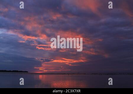 Exotische rote Wolken bei Sonnenuntergang am tropischen Strand. Rote und blaue Wolkenstruktur an einem bewölkten Tag in tropischer Landschaft auf Gili Air Island, Lombok, Indonesien Stockfoto