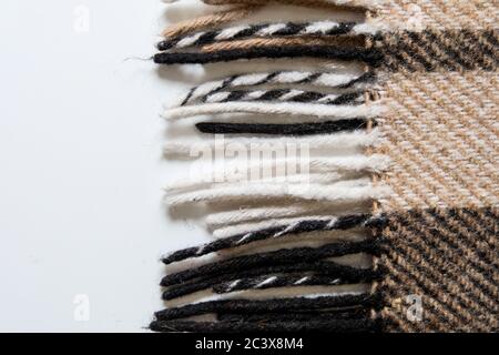 Braune Karaid Decke mit langen Kanten. Nahaufnahme auf einer weißen Fläche. Textil im Interior Design. Wärmendes, gemütliches Material zum Verdecken beim Lernen Stockfoto