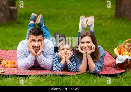 Portrait der jungen Familie, die zusammen mit ihrem Sohn Picknick im Freien Stockfoto