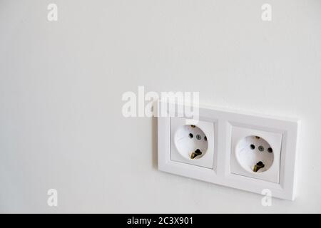 Zwei weiße europäische Hochspannungs-220W-Steckdosen an einer weißen Wand mit leerem Kopierraum. Typische moderne Inneneinrichtung. Essentials in Haus neu dekorieren Stockfoto