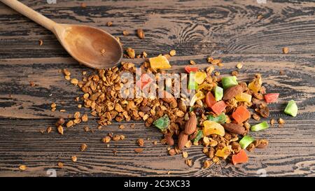 Rustikale Morgen gesunde Lebensmittel. Farbiger und heller Hintergrund. Süße Flocken mit Nüssen und Früchten auf braunem Holztisch Stockfoto