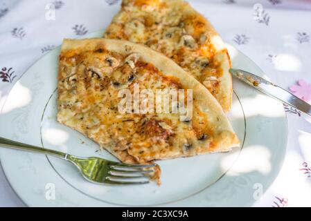 Pizzateile auf einem Teller auf einem Tisch mit Tischdecke und Besteck, Deutschland Stockfoto
